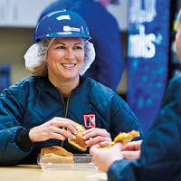 Woman eating lunch with hard hat on